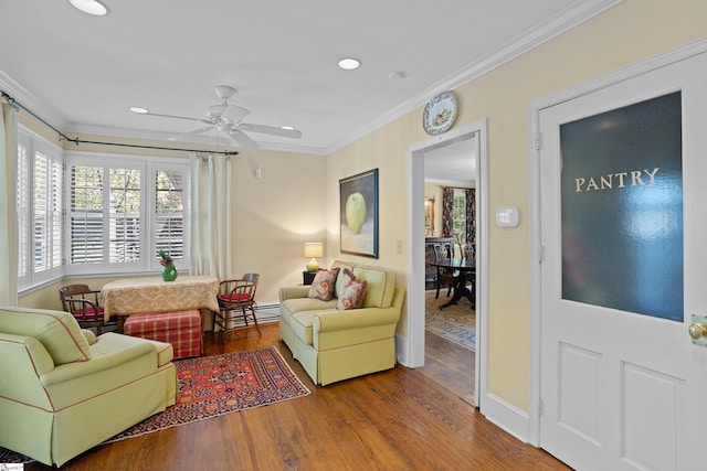 living room featuring crown molding, hardwood / wood-style floors, a baseboard radiator, and ceiling fan