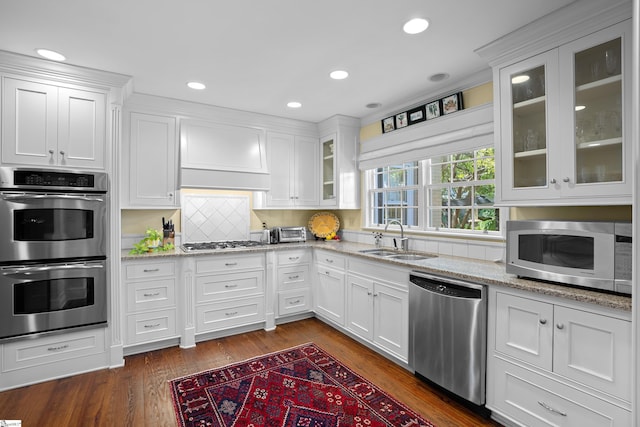 kitchen featuring appliances with stainless steel finishes, white cabinetry, sink, and dark hardwood / wood-style flooring