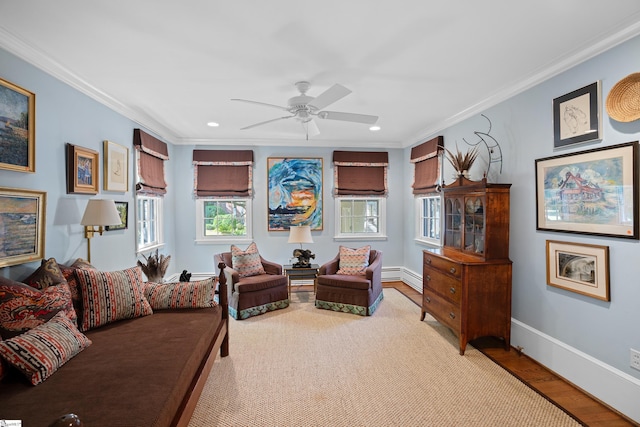 living room featuring crown molding, light hardwood / wood-style flooring, and ceiling fan