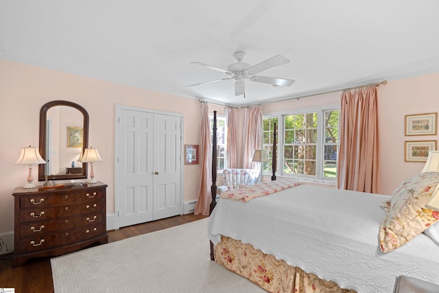 bedroom featuring dark hardwood / wood-style floors, a closet, baseboard heating, ornamental molding, and ceiling fan