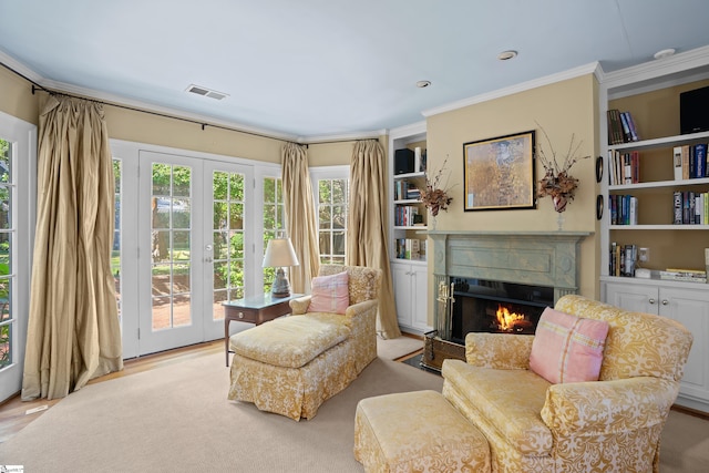 living area with light hardwood / wood-style flooring, ornamental molding, and french doors