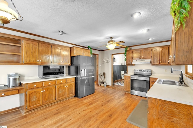 kitchen with ceiling fan, appliances with stainless steel finishes, light wood-type flooring, crown molding, and sink