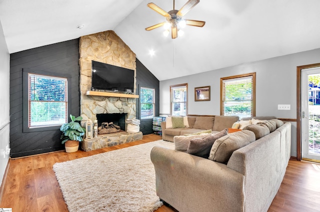 living room with light hardwood / wood-style floors, lofted ceiling, a fireplace, and ceiling fan