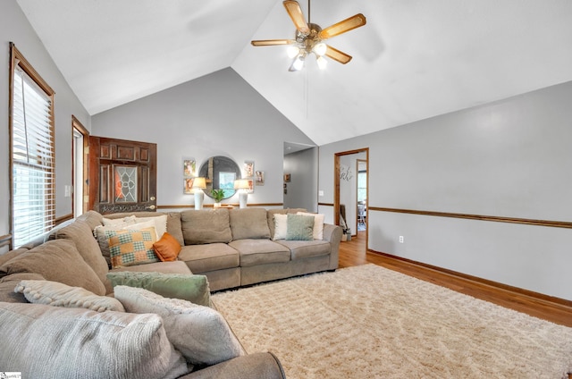 living room featuring ceiling fan, high vaulted ceiling, and light wood-type flooring