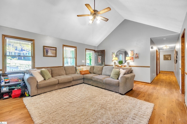 living room featuring light hardwood / wood-style floors, high vaulted ceiling, and plenty of natural light