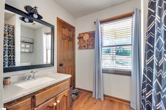 bathroom with vanity, a textured ceiling, hardwood / wood-style flooring, and toilet