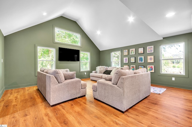 living room with lofted ceiling, light hardwood / wood-style flooring, and plenty of natural light