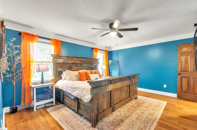 bedroom featuring ceiling fan, crown molding, a textured ceiling, and light wood-type flooring