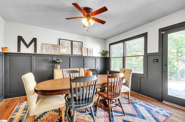 dining room with a textured ceiling, light hardwood / wood-style floors, and ceiling fan