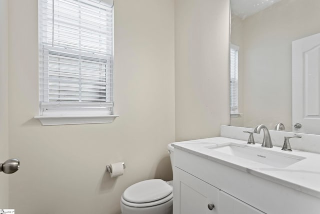 bathroom with vanity, toilet, and plenty of natural light