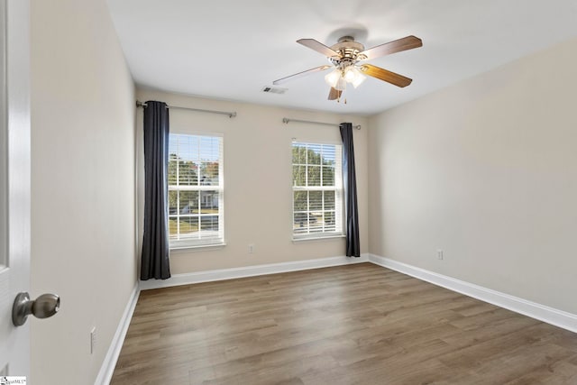 spare room featuring dark wood-type flooring and ceiling fan