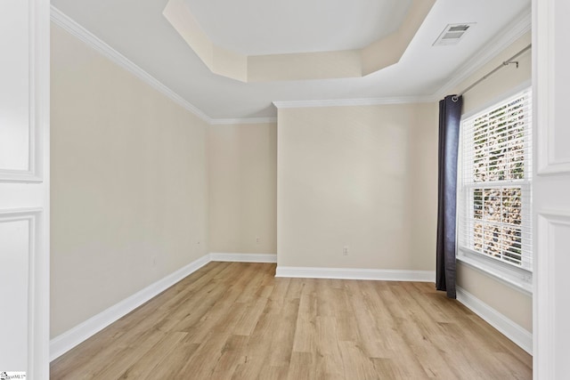 unfurnished room featuring light hardwood / wood-style floors, ornamental molding, and a tray ceiling