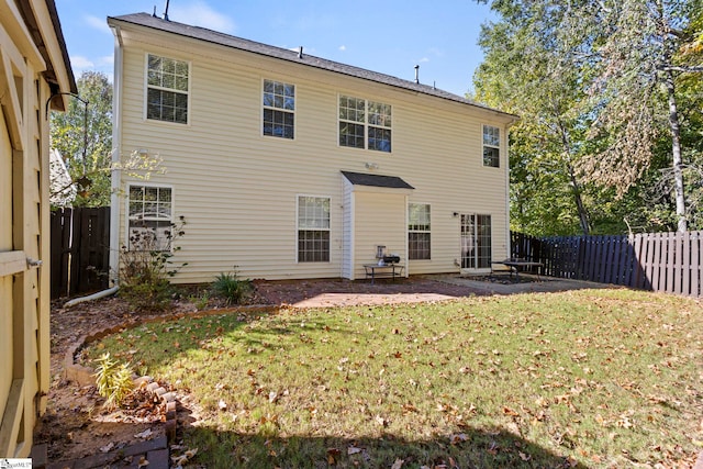 rear view of property featuring a patio and a lawn