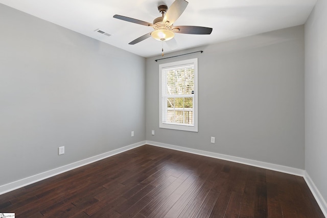 spare room featuring dark wood-type flooring and ceiling fan