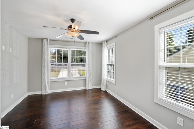 spare room featuring ceiling fan, a healthy amount of sunlight, and dark hardwood / wood-style flooring