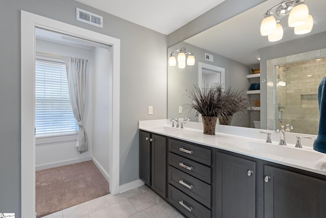 bathroom featuring a shower with door, vanity, and tile patterned flooring