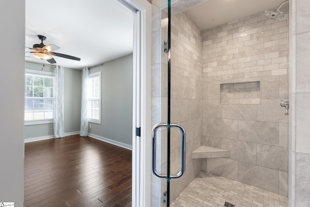 bathroom with ceiling fan, wood-type flooring, and a shower with shower door