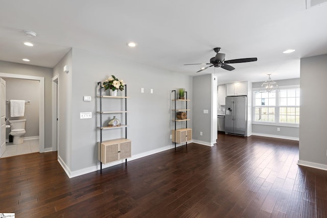 unfurnished living room with dark wood-type flooring and ceiling fan with notable chandelier