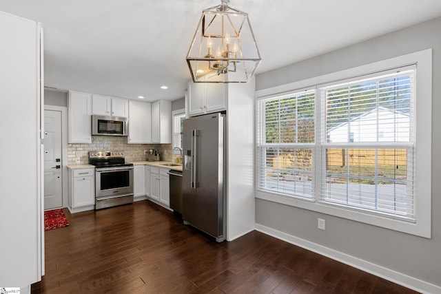 kitchen featuring white cabinetry, decorative light fixtures, stainless steel appliances, and dark hardwood / wood-style floors