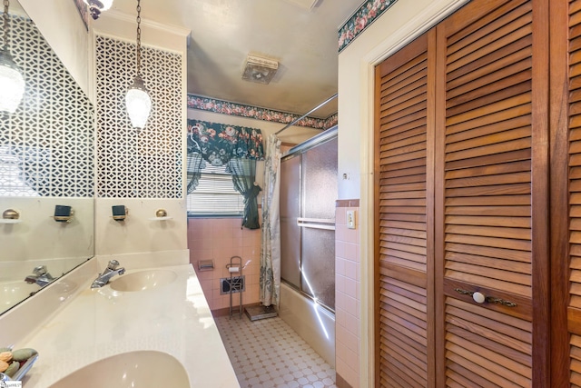 bathroom featuring vanity and enclosed tub / shower combo