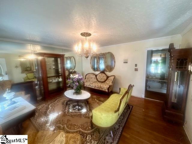 dining room featuring a chandelier, a textured ceiling, dark hardwood / wood-style floors, and crown molding