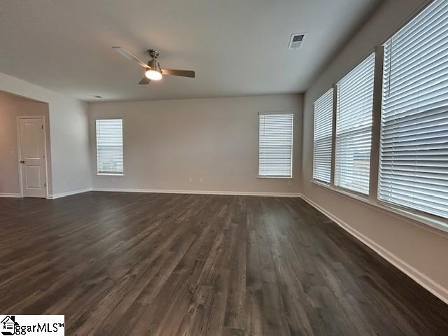 empty room featuring ceiling fan and dark wood-type flooring