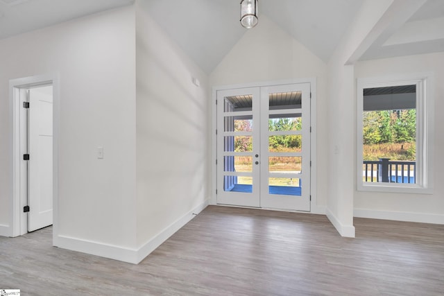 entryway featuring light hardwood / wood-style flooring, french doors, vaulted ceiling, and a wealth of natural light