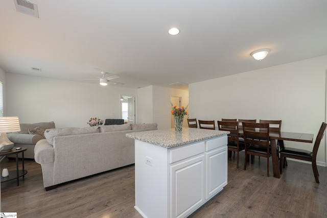 kitchen featuring a center island, white cabinets, dark hardwood / wood-style floors, and ceiling fan