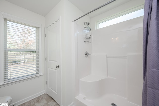 bathroom with toilet, a healthy amount of sunlight, and a shower with shower curtain