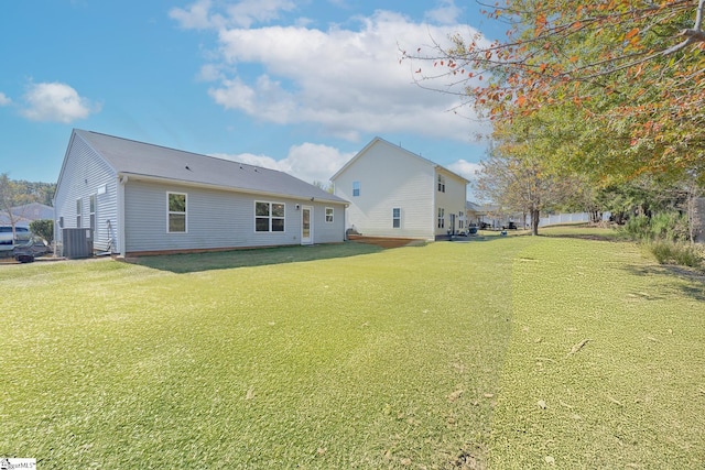 rear view of house with a patio area, central AC, and a yard