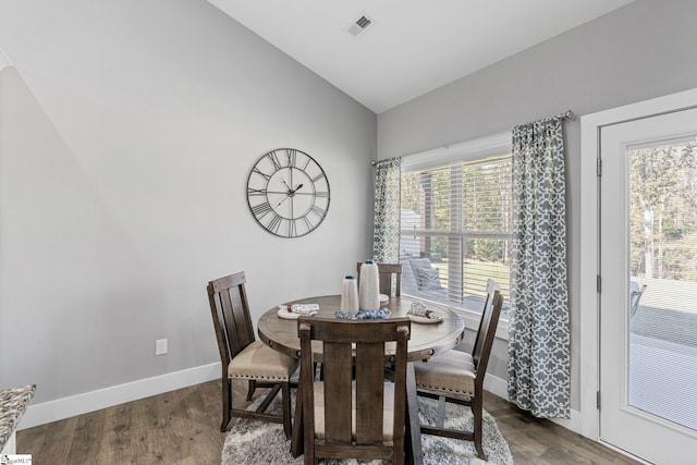 dining room featuring hardwood / wood-style flooring, a healthy amount of sunlight, and lofted ceiling