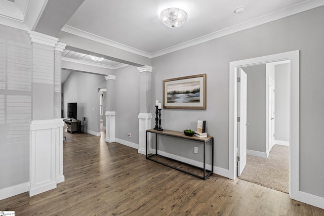 corridor featuring ornate columns, crown molding, and dark hardwood / wood-style flooring