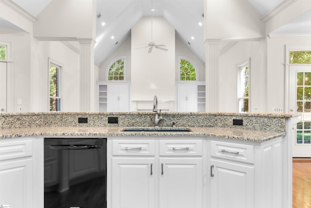 kitchen featuring black dishwasher, decorative columns, white cabinets, and sink