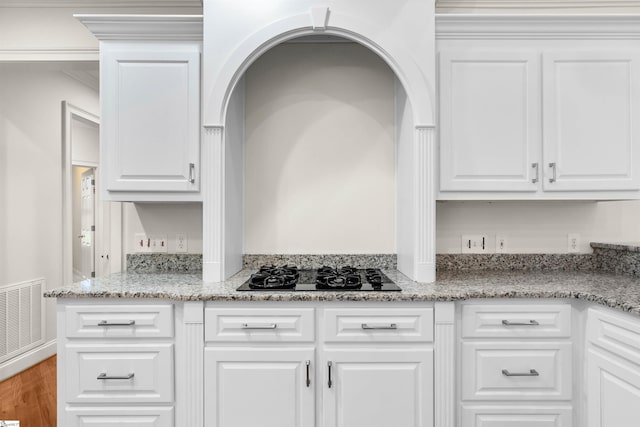 kitchen featuring black gas cooktop, white cabinetry, light stone countertops, and hardwood / wood-style floors