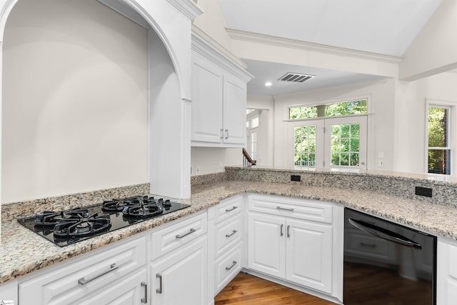 kitchen with lofted ceiling, white cabinets, black appliances, and light wood-type flooring