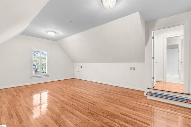 bonus room with lofted ceiling and light hardwood / wood-style floors