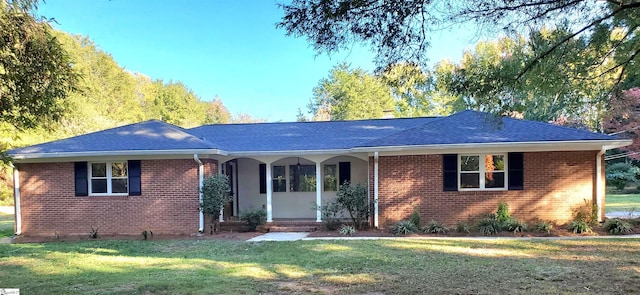 ranch-style house featuring covered porch and a front lawn