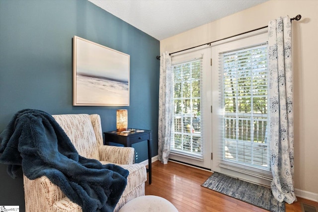 sitting room with wood-type flooring and a textured ceiling