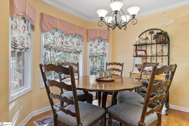 dining area with a notable chandelier, crown molding, and hardwood / wood-style flooring