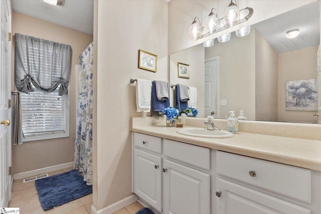 bathroom with vanity, a textured ceiling, and tile patterned floors