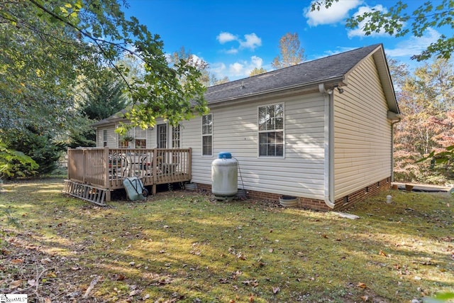 rear view of property with a yard and a wooden deck