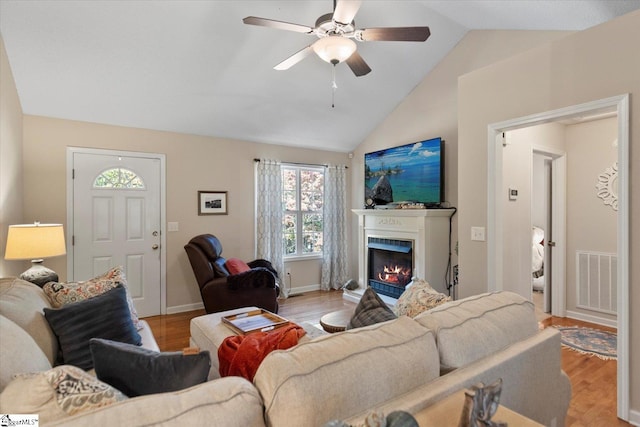 living room with lofted ceiling, light wood-type flooring, and ceiling fan