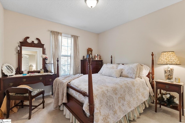 bedroom featuring light carpet and a textured ceiling