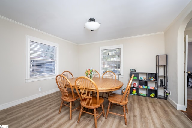 dining room with crown molding and light hardwood / wood-style flooring