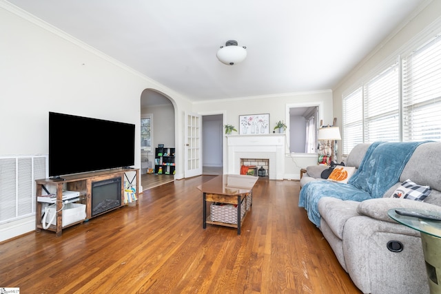 living room featuring crown molding, hardwood / wood-style flooring, and a fireplace