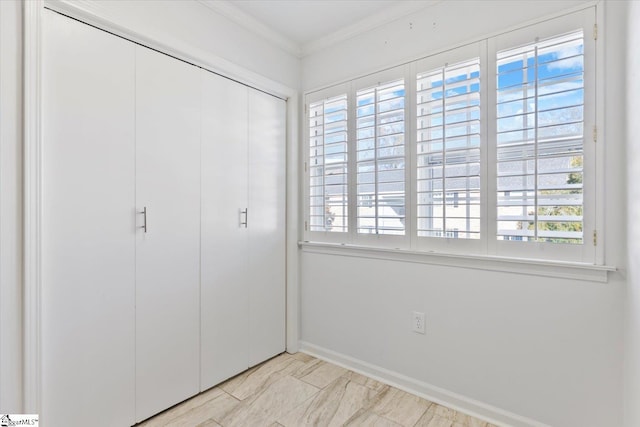 unfurnished bedroom featuring crown molding and a closet