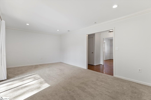 spare room with crown molding and dark colored carpet