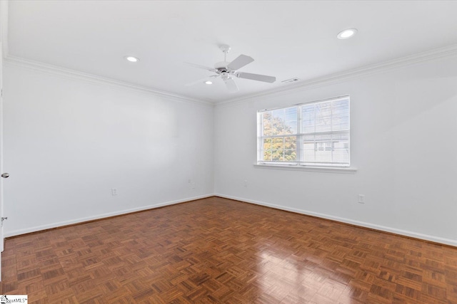 spare room featuring crown molding, dark parquet floors, and ceiling fan