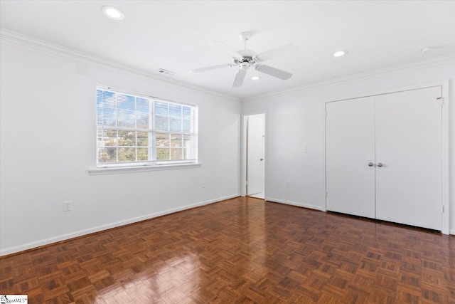 unfurnished bedroom with ornamental molding, a closet, dark parquet flooring, and ceiling fan