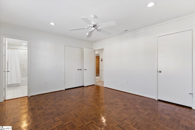 unfurnished bedroom with connected bathroom, dark parquet floors, ornamental molding, and ceiling fan